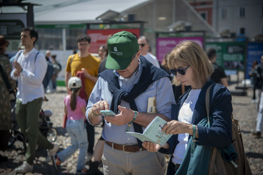 una coppia consulta il libretto con il programma del Festival in piazza Sordello